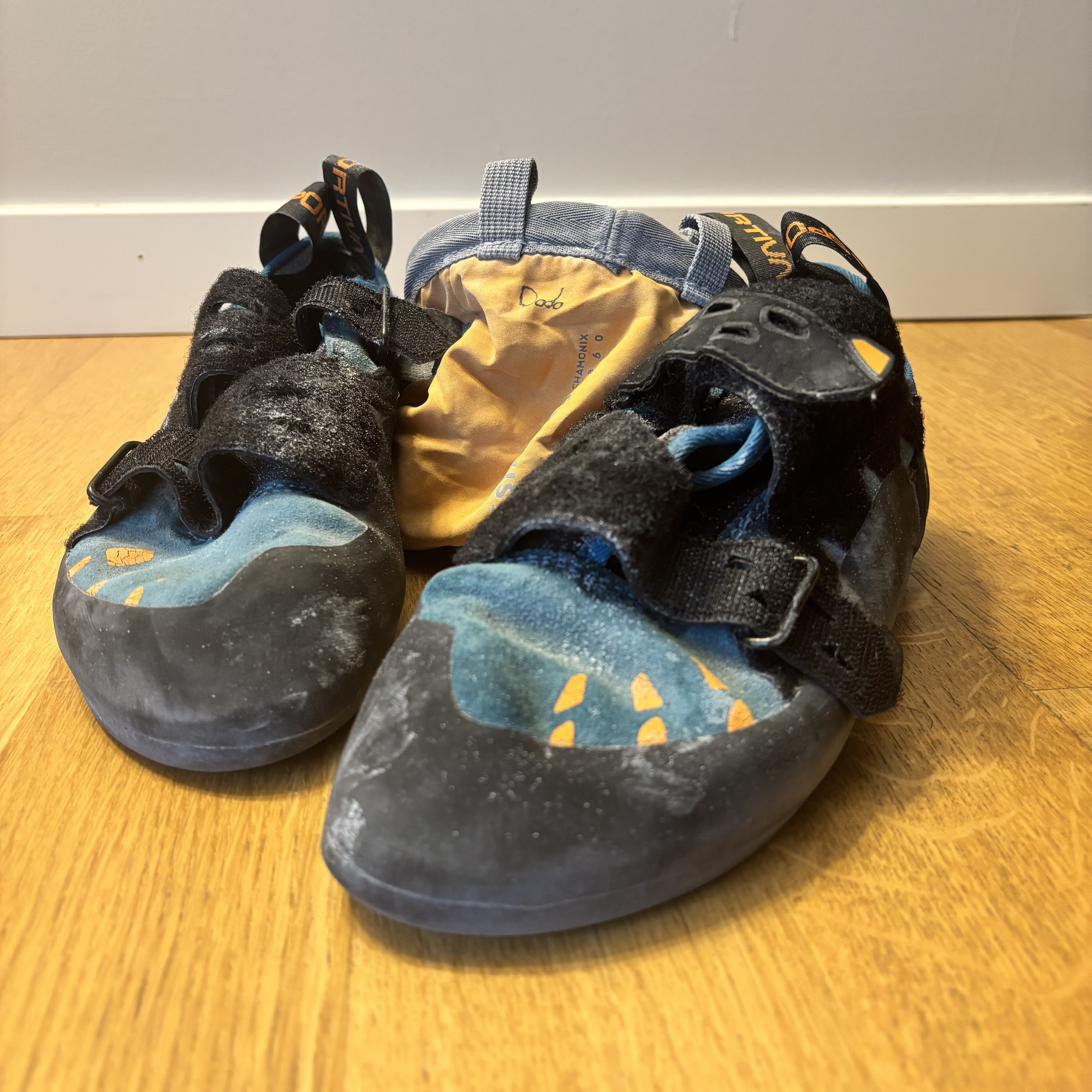 A pair of bouldering shoes next to a chalk bag.