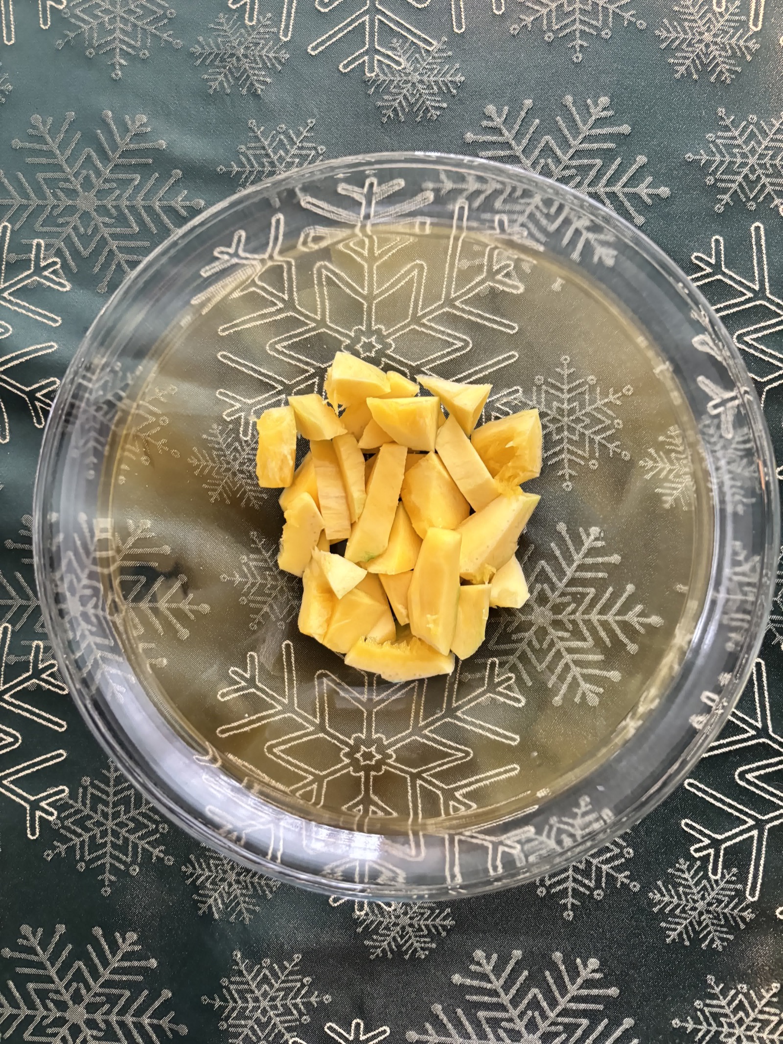 Mango pieces in a clear mixing bowl.