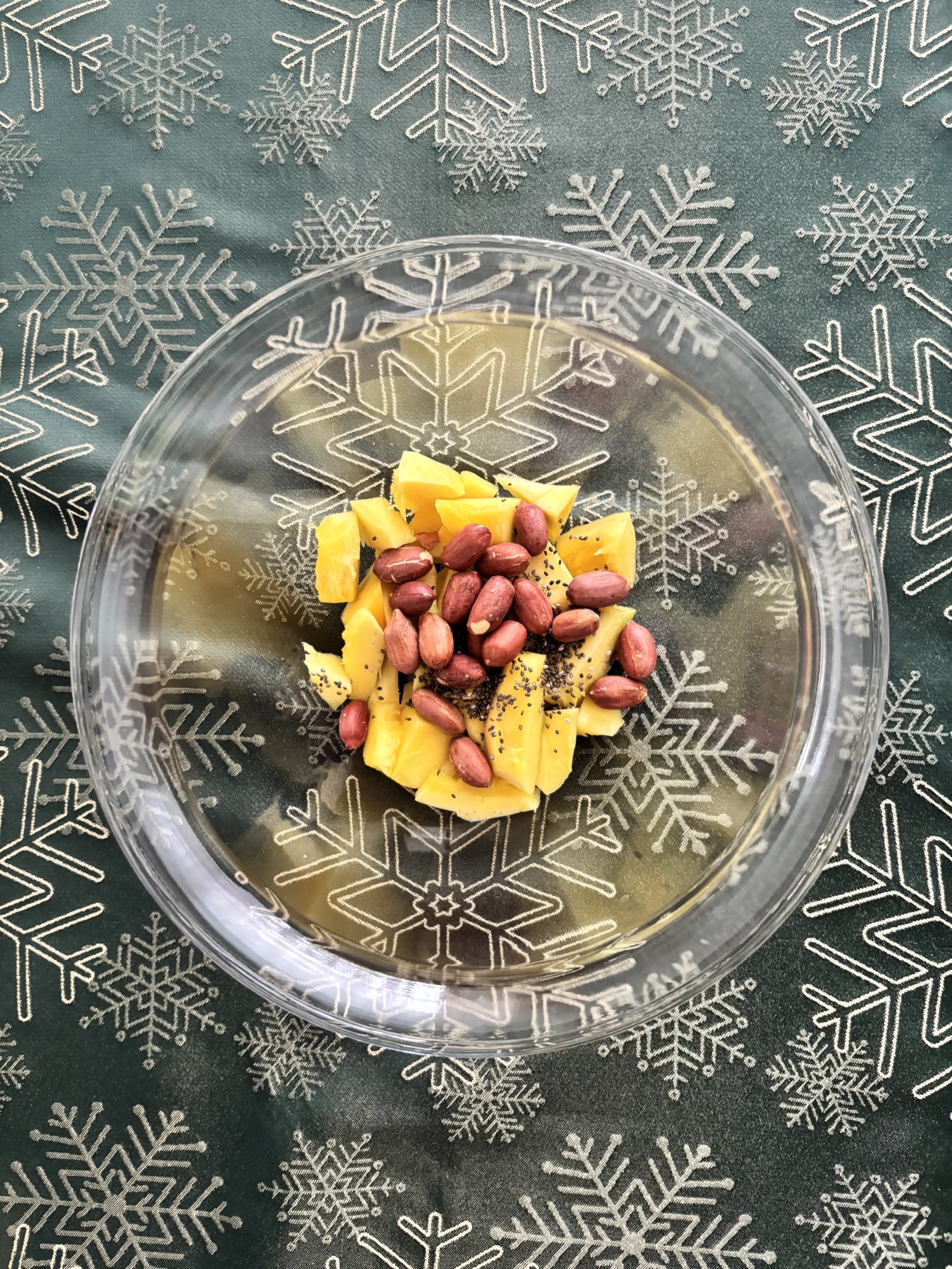 Mango, chia seeds, and peanuts in a bowl.
